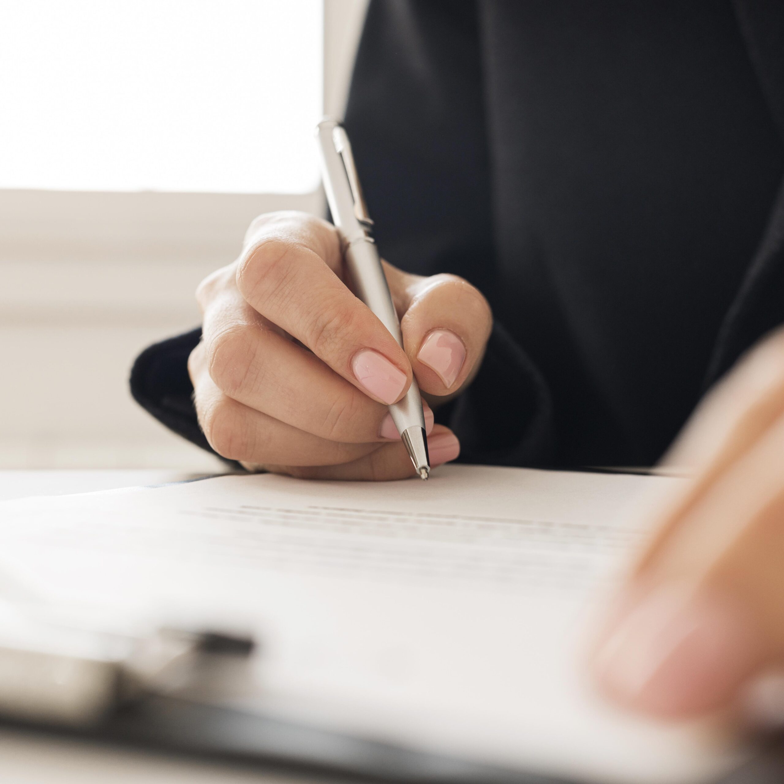 close-up-person-signing-certificate-scaled.jpg